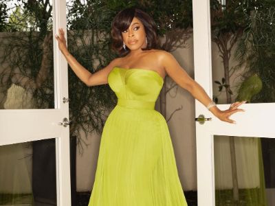 Niecy Nash is posing for a picture in a green sleeveless dress.